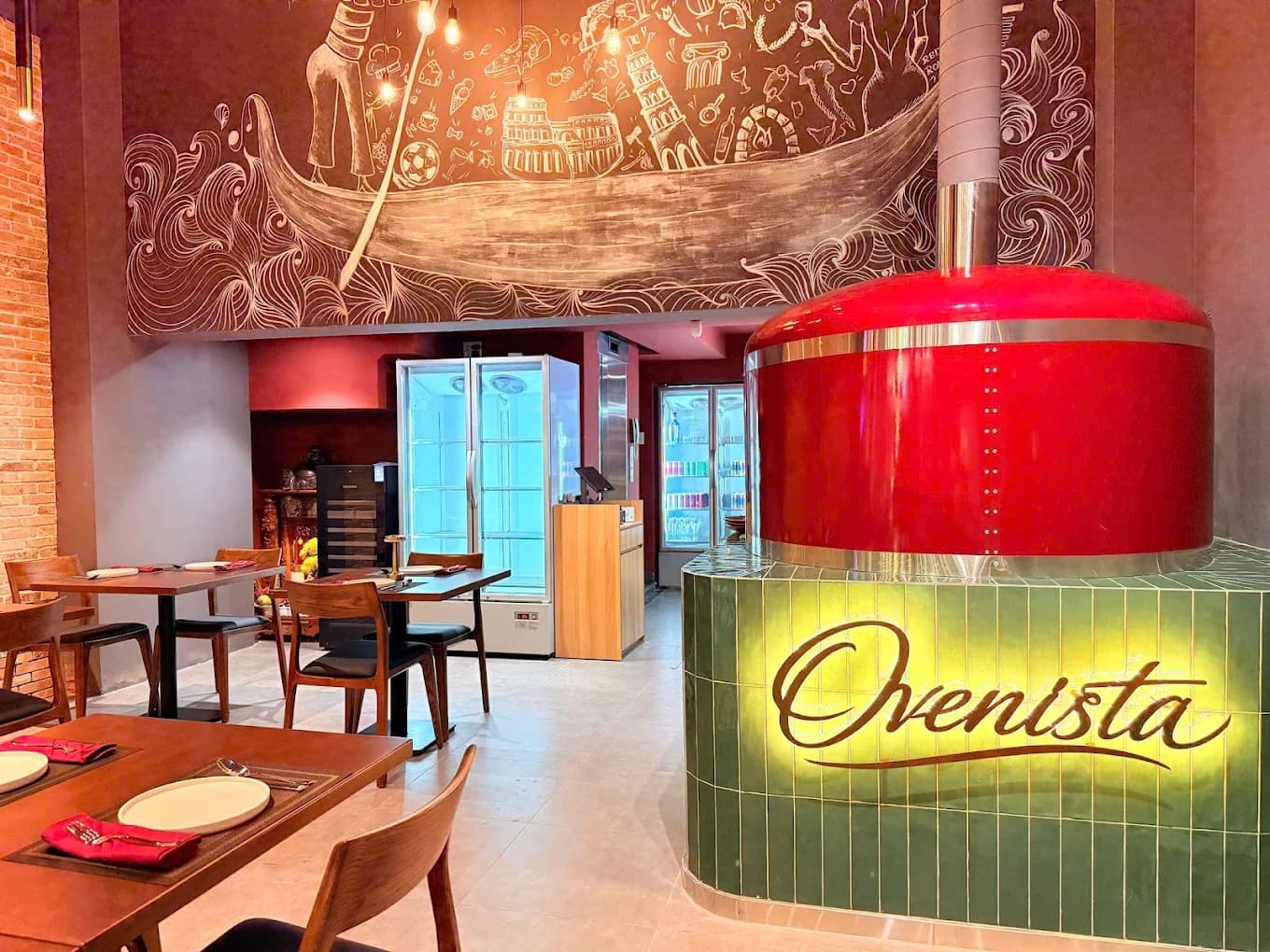 Ovenista interior with exposed brick and dark wood tables